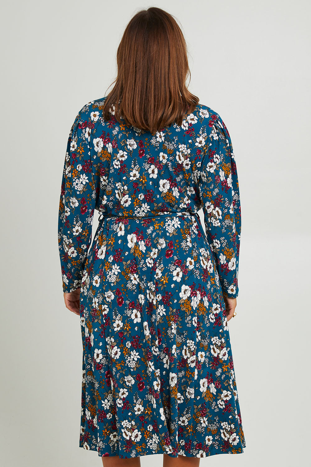 Model Monique wearing size 14 of the Belle Printed Faux Wrap Dress in colour Tealfleur (Green), from the back