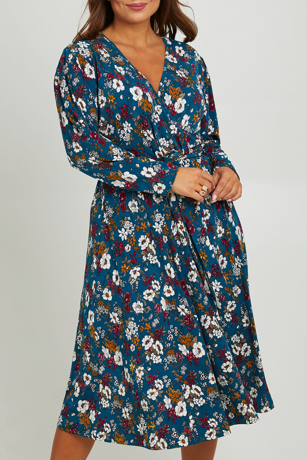 Model Monique wearing size 14 of the Belle Printed Faux Wrap Dress in colour Tealfleur (Green), from the front, cropped image