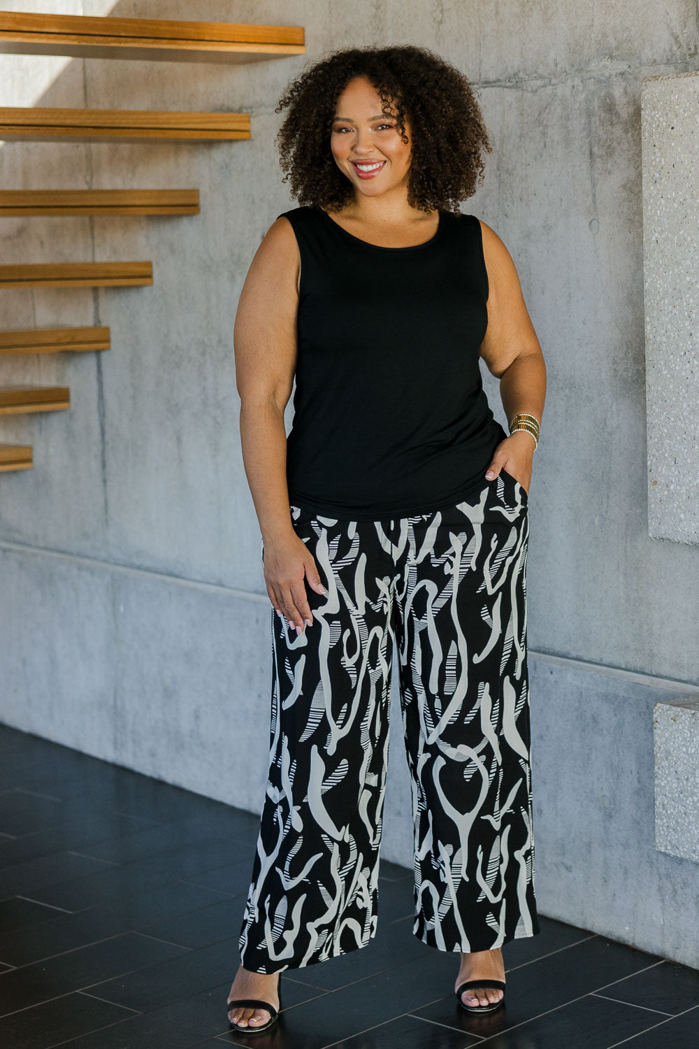 Model Alexis wearing size 18 of the Belle Relaxed Wide Leg Pull On Pant in colour Blackivory (Black), from the front, showing the whole outfit
