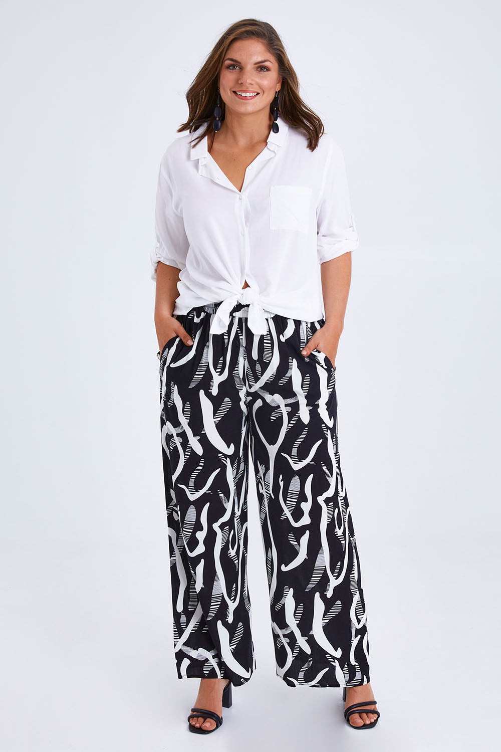 Model Monique wearing size 14 of the Belle Relaxed Wide Leg Pull On Pant in colour Blackivory (Black), from the front, showing the whole outfit