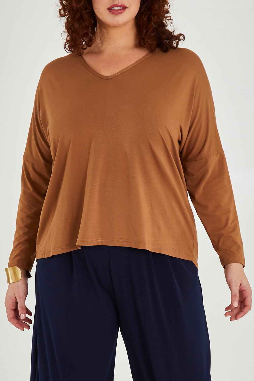 Model Maddy wearing size 16 of the Belle Luxe Bamboo V Neck Tee in colour Tawny, from the front, cropped image
