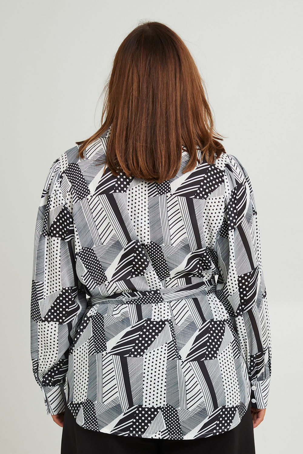 Model Monique wearing size 14 of the Belle Full Sleeve Printed Shirt in colour Blackivory (Black), from the back