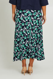 Model Monique wearing size 14 of the Belle Wide Waistband Pull On Skirt in colour Navyfloral (Blue), from the back