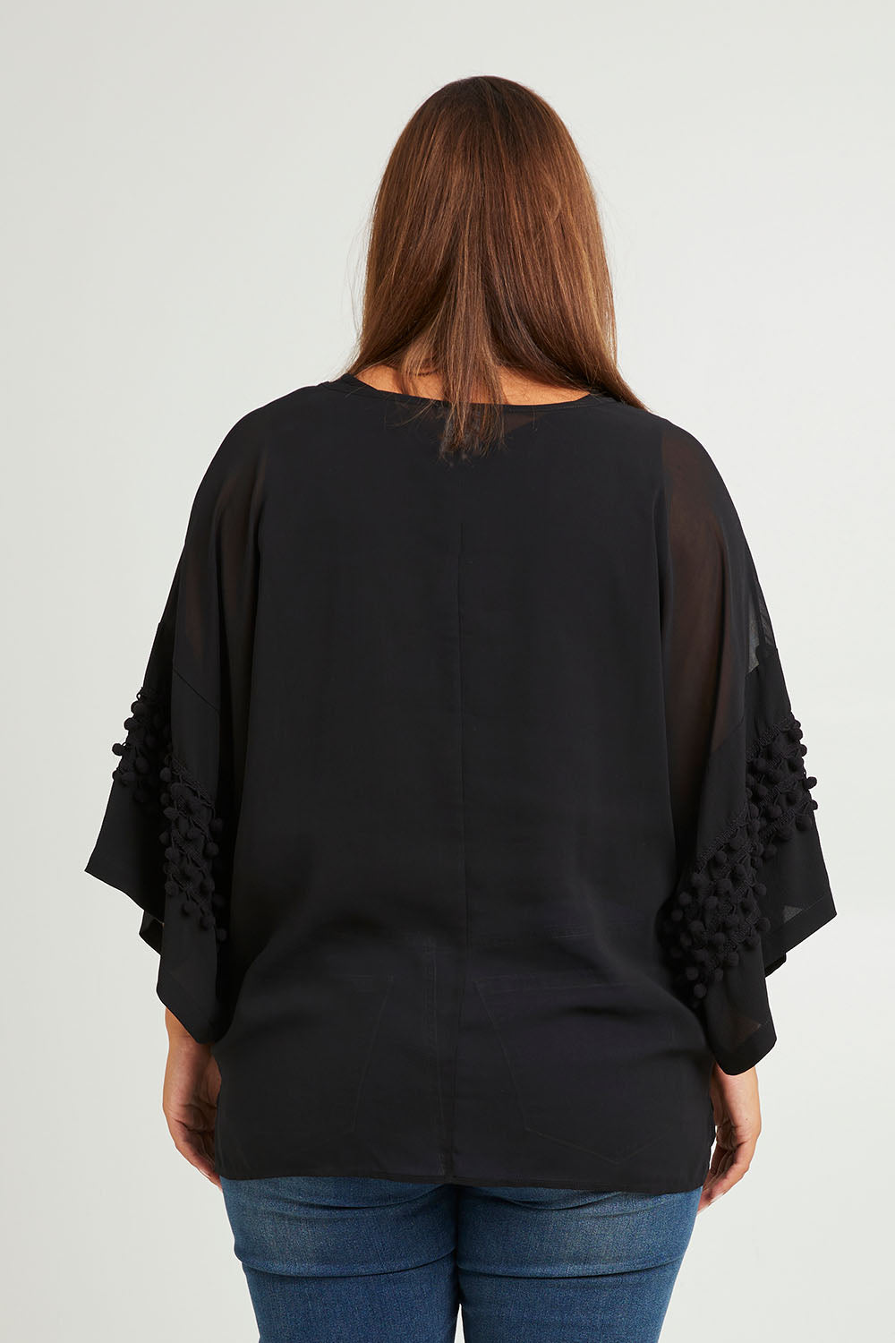 Model Monique wearing size 14 of the Belle Chiffon Bubble Detail Top w/Cami in colour Black (Black), from the back