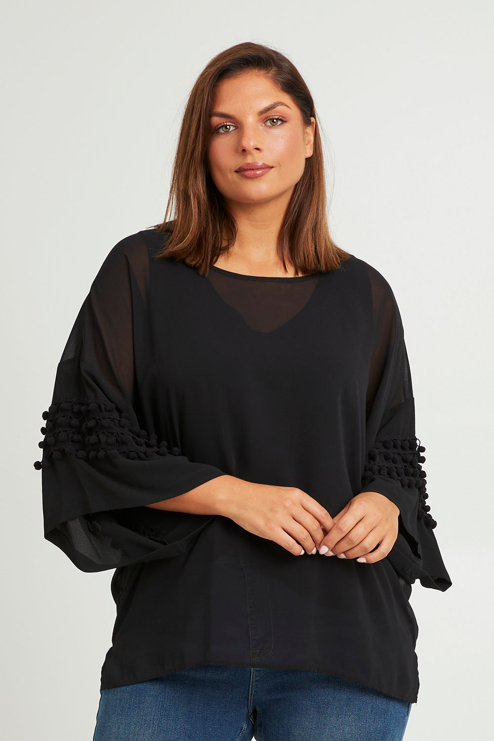 Model Monique wearing size 14 of the Belle Chiffon Bubble Detail Top w/Cami in colour Black (Black), from the front, cropped image