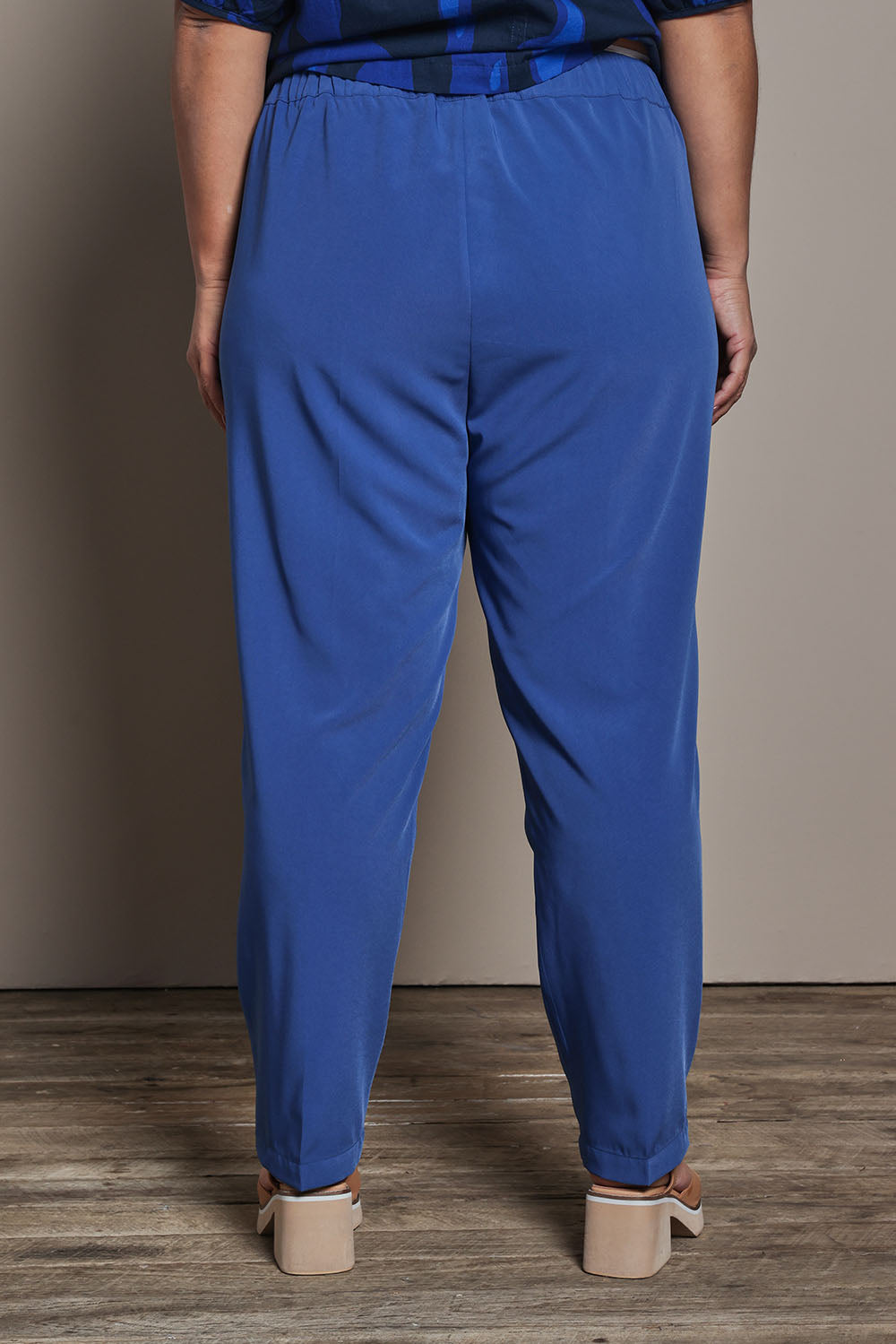 Model Ashleigh wearing size 16 of the Belle Pull On Tailored Soft Suiting  Pant in colour Ink (Blue), from the back