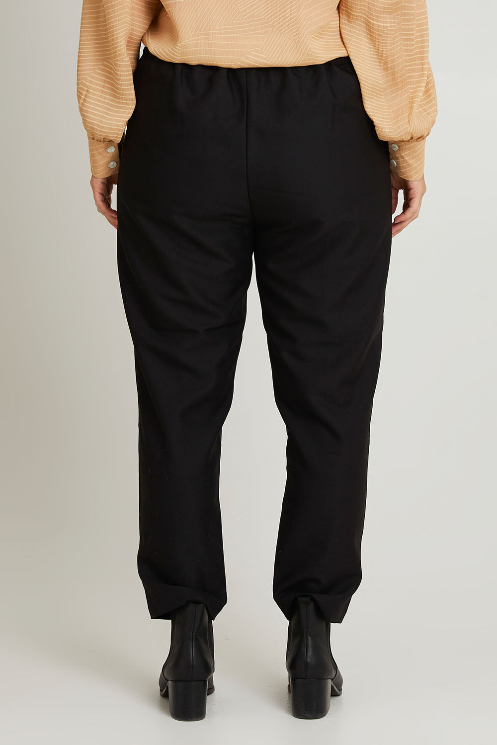 Model Laura wearing size 14 of the Belle Pull On Tailored Pant in colour Black (Black), from the back