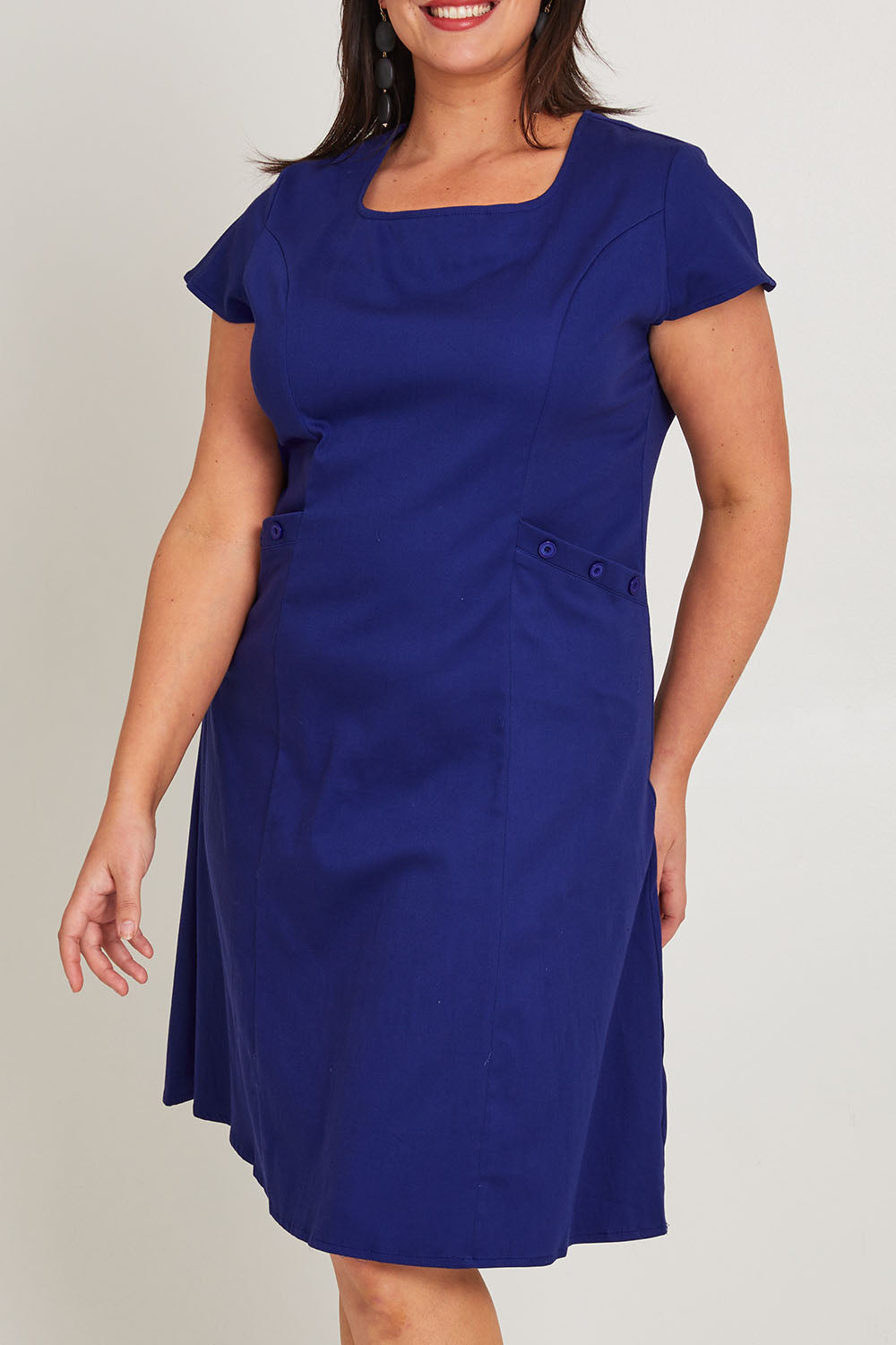 Model Poppy wearing size 16 of the Belle A Line Cotton Sateen Dress in colour Sapphire (Blue), from the front, cropped image