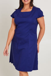 Model Poppy wearing size 16 of the Belle A Line Cotton Sateen Dress in colour Sapphire (Blue), from the front, cropped image