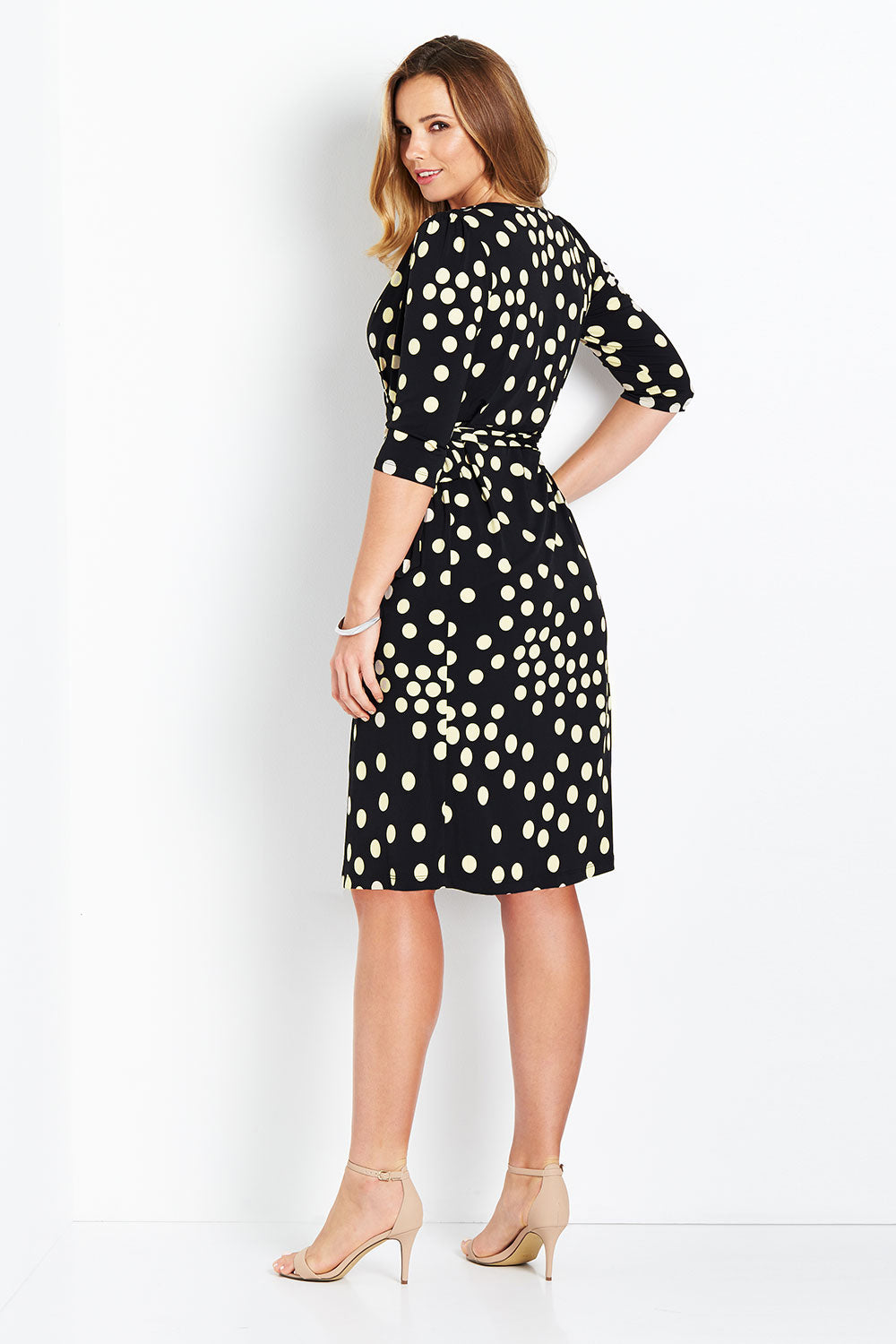 Model Bree wearing size 14 of the Belle Spot Print Wrap Dress in colour Black (Black), from the back