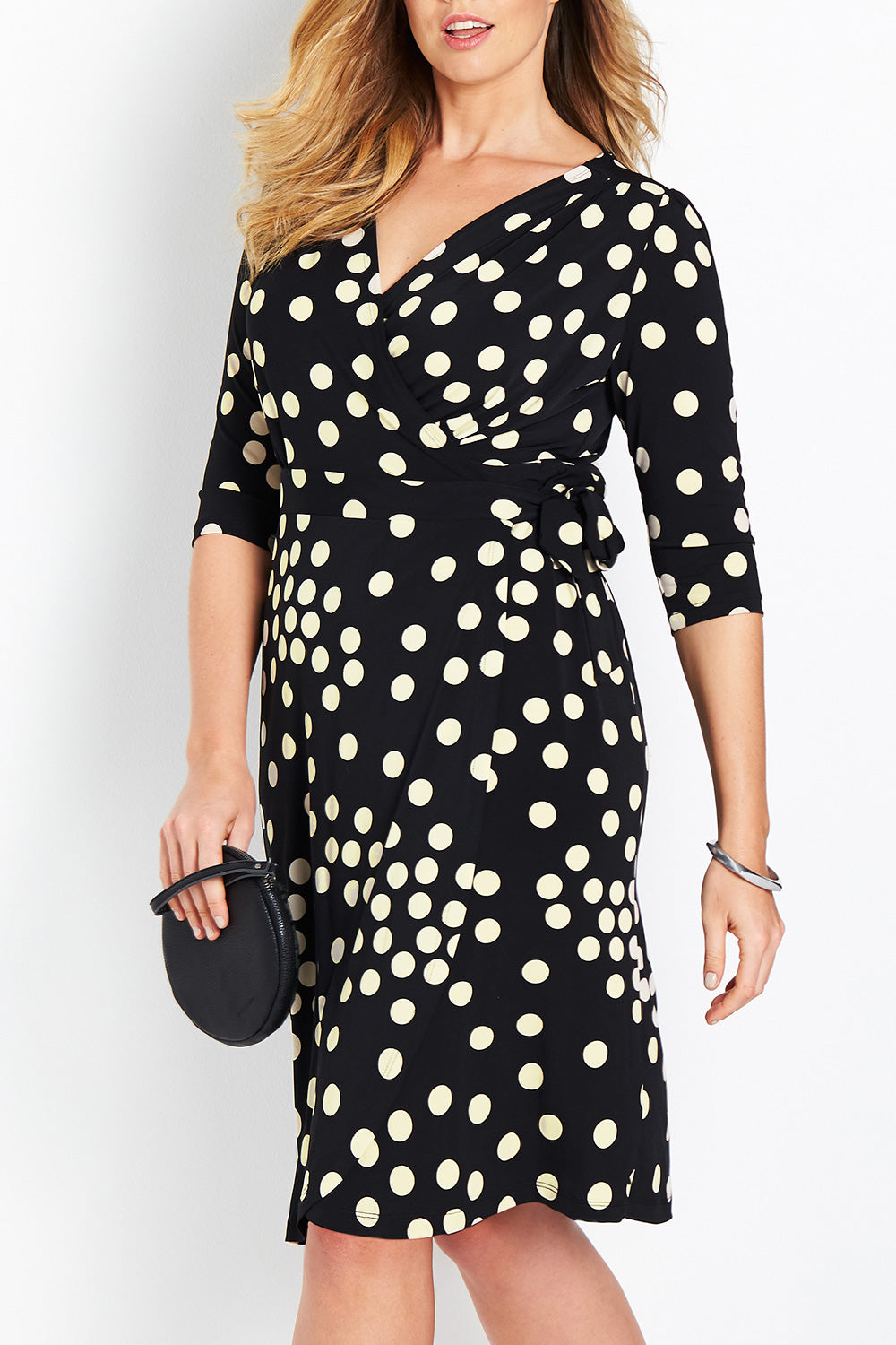Model Bree wearing size 14 of the Belle Spot Print Wrap Dress in colour Black (Black), from the front, cropped image