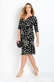 Model Bree wearing size 14 of the Belle Spot Print Wrap Dress in colour Black (Black), from the front, showing the whole outfit