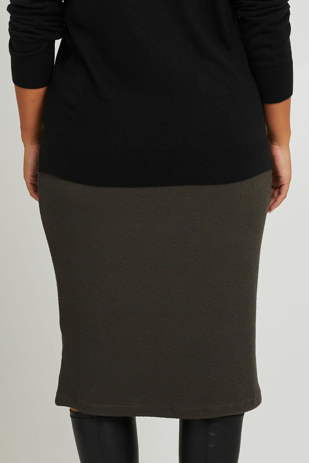 Model Monique wearing size 14 of the Belle Textured Pull On Skirt in colour Pinegreen (Green), from the back