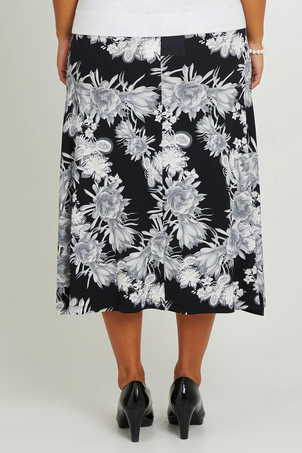 Model Monique wearing size 14 of the Belle Printed Flared Skirt in colour Blackgrey (Black), from the back