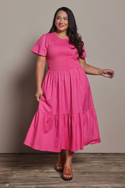 Model Ashleigh wearing size 16 of the Belle Cotton Shirred Bodice Dress in colour Candypink (Pink), from the front, showing the whole outfit