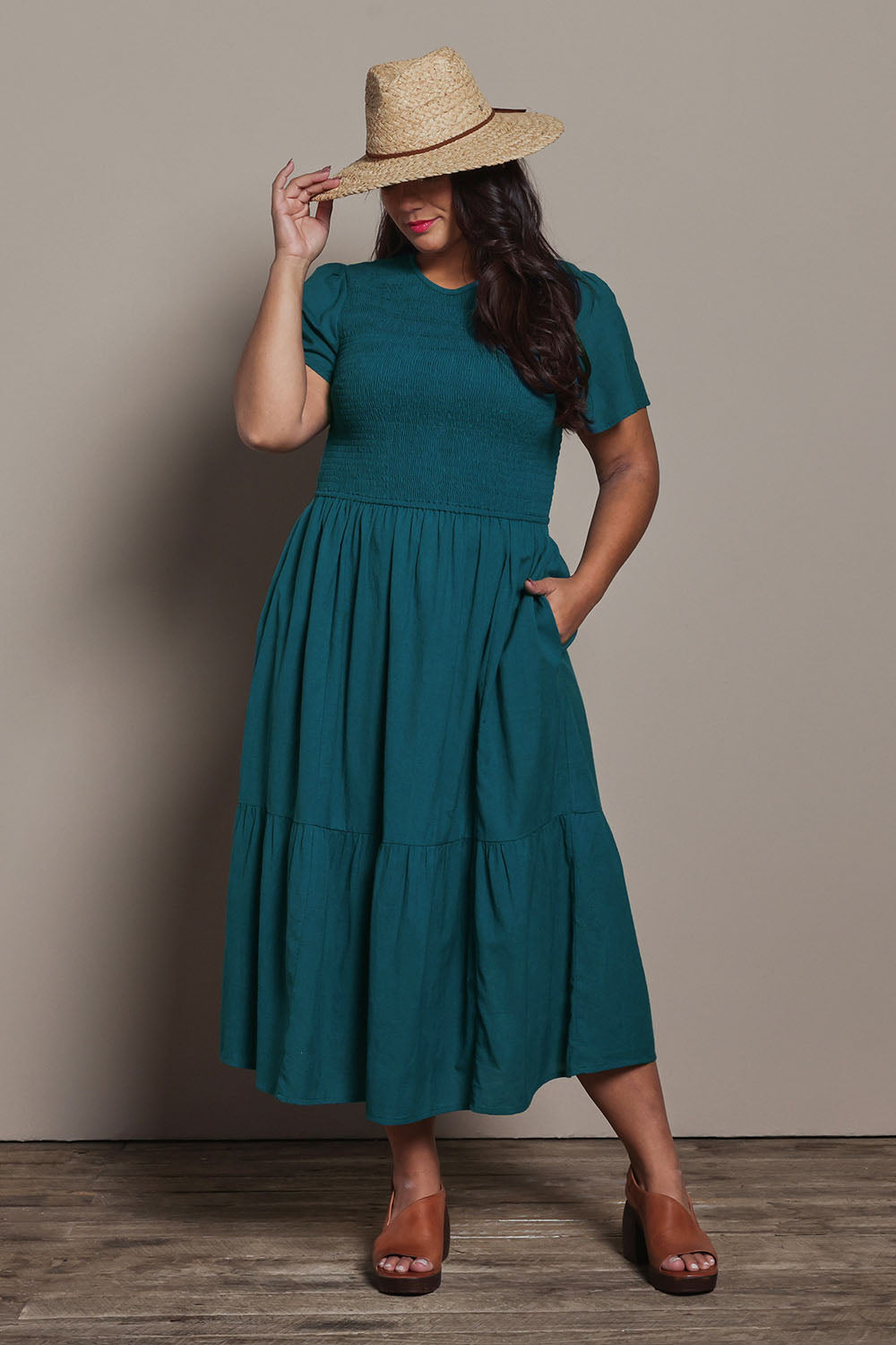 Model Ashleigh wearing size 16 of the Belle Cotton Shirred Bodice Dress in colour Deepocean (Green), from the front, showing the whole outfit