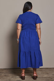 Model Ashleigh wearing size 16 of the Belle Cotton Shirred Bodice Dress in colour Marineblue (Blue), from the back