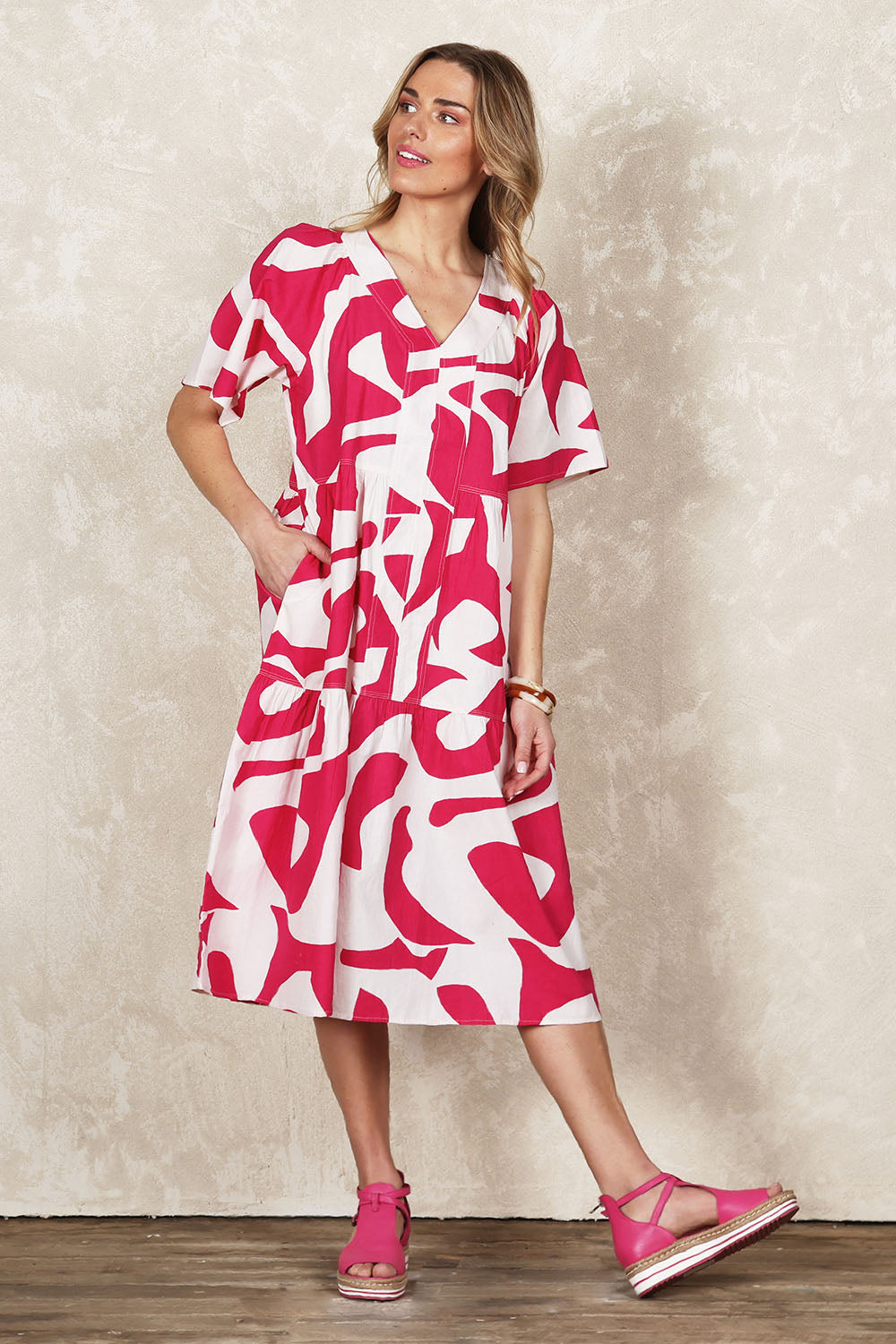 Model Olivia wearing size 10 of the Belle V Panel Tier Dress in colour Pinksorbet (Pink), from the front, showing the whole outfit