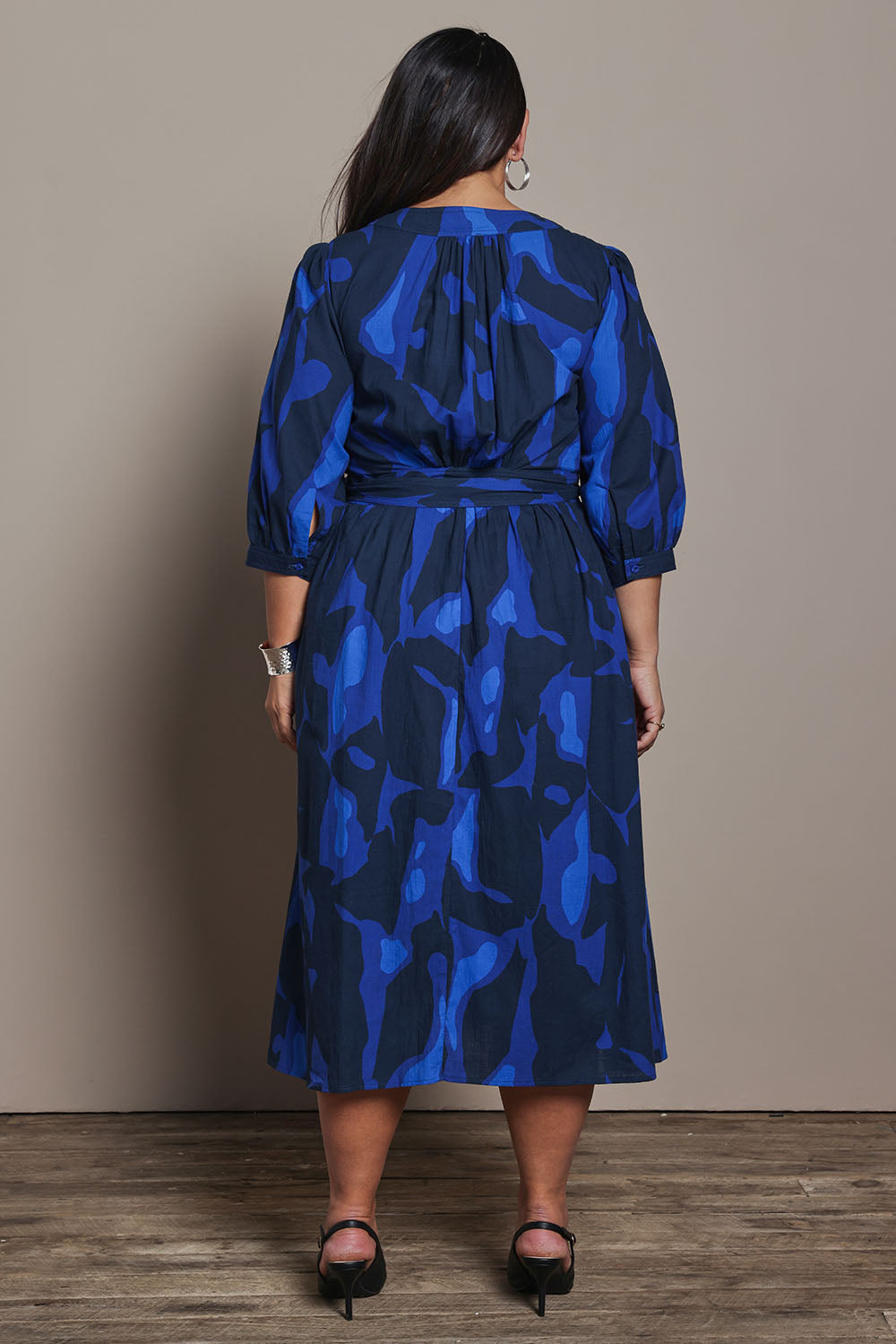 Model Ashleigh wearing size 16 of the Belle Puff Sleeve Printed  Cotton Wrap Dress in colour Trioofblue (Blue), from the back