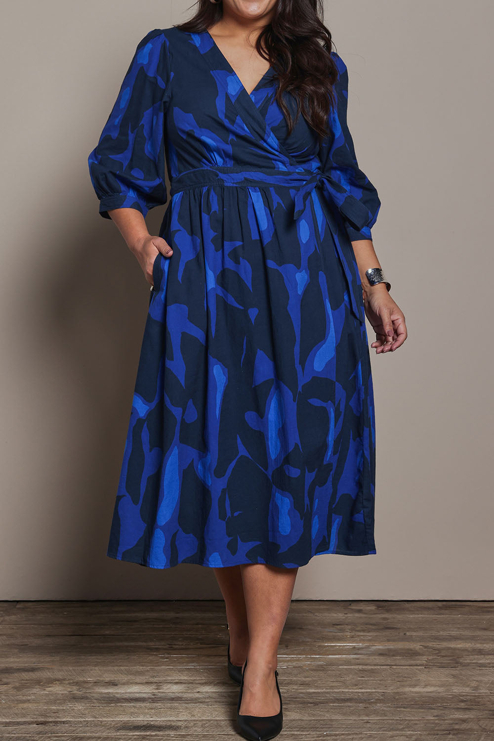 Model Ashleigh wearing size 16 of the Belle Puff Sleeve Printed  Cotton Wrap Dress in colour Trioofblue (Blue), from the front, cropped image
