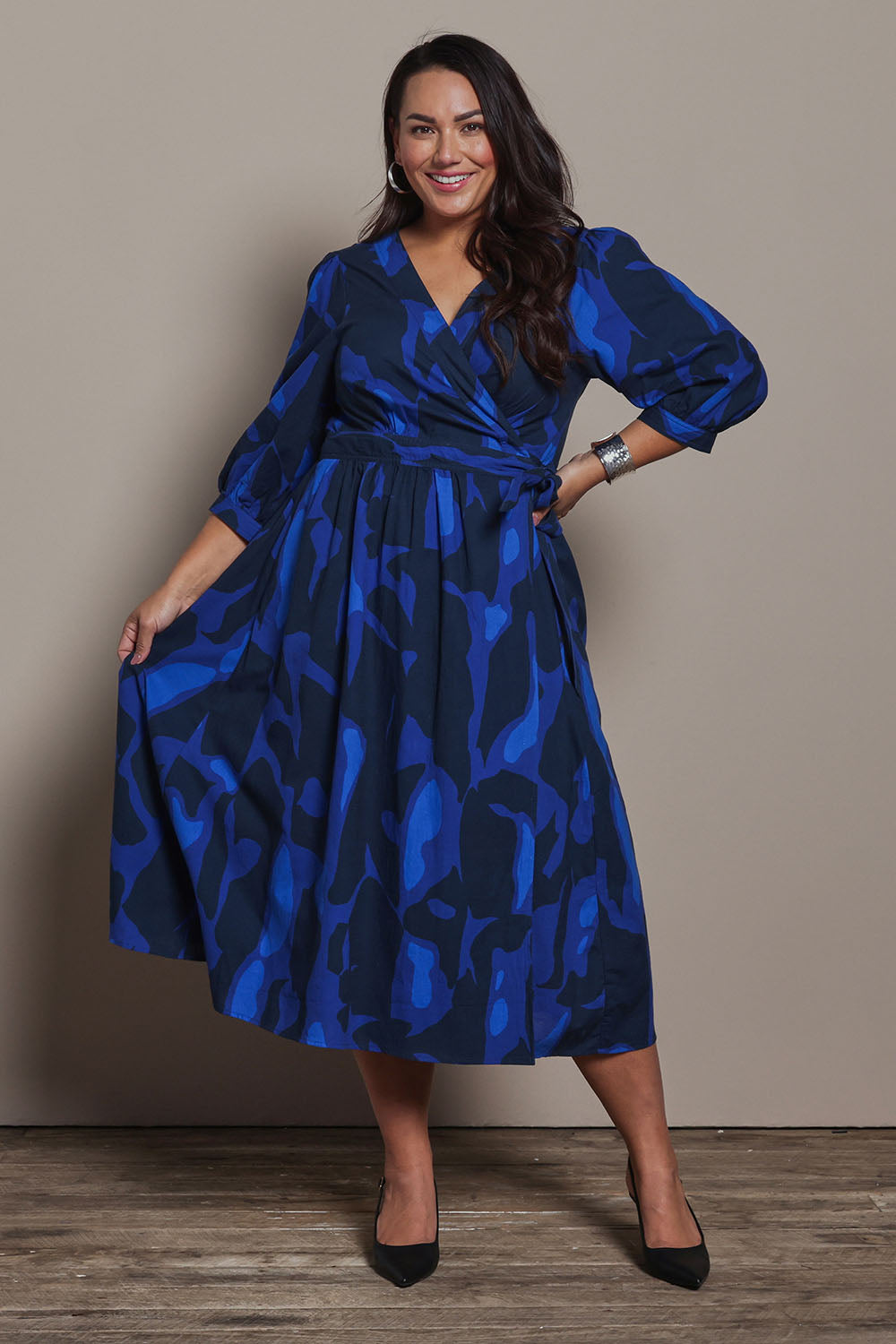 Model Ashleigh wearing size 16 of the Belle Puff Sleeve Printed  Cotton Wrap Dress in colour Trioofblue (Blue), from the front, showing the whole outfit