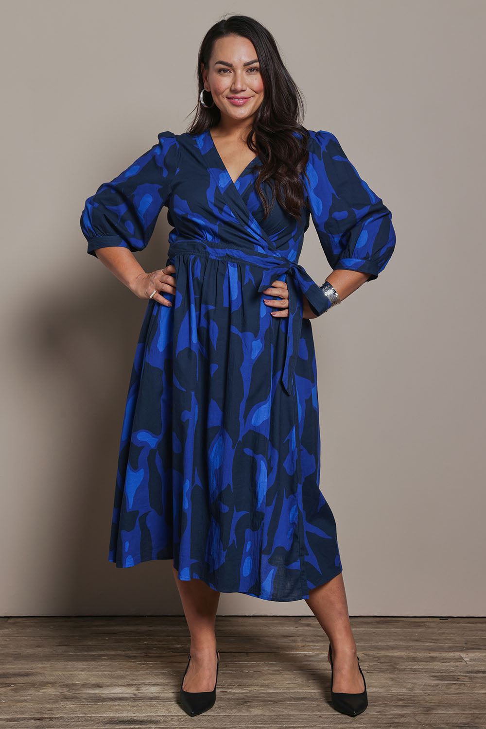 Model Ashleigh wearing size 16 of the Belle Puff Sleeve Printed  Cotton Wrap Dress in colour Trioofblue (Blue), from the front, showing the whole outfit