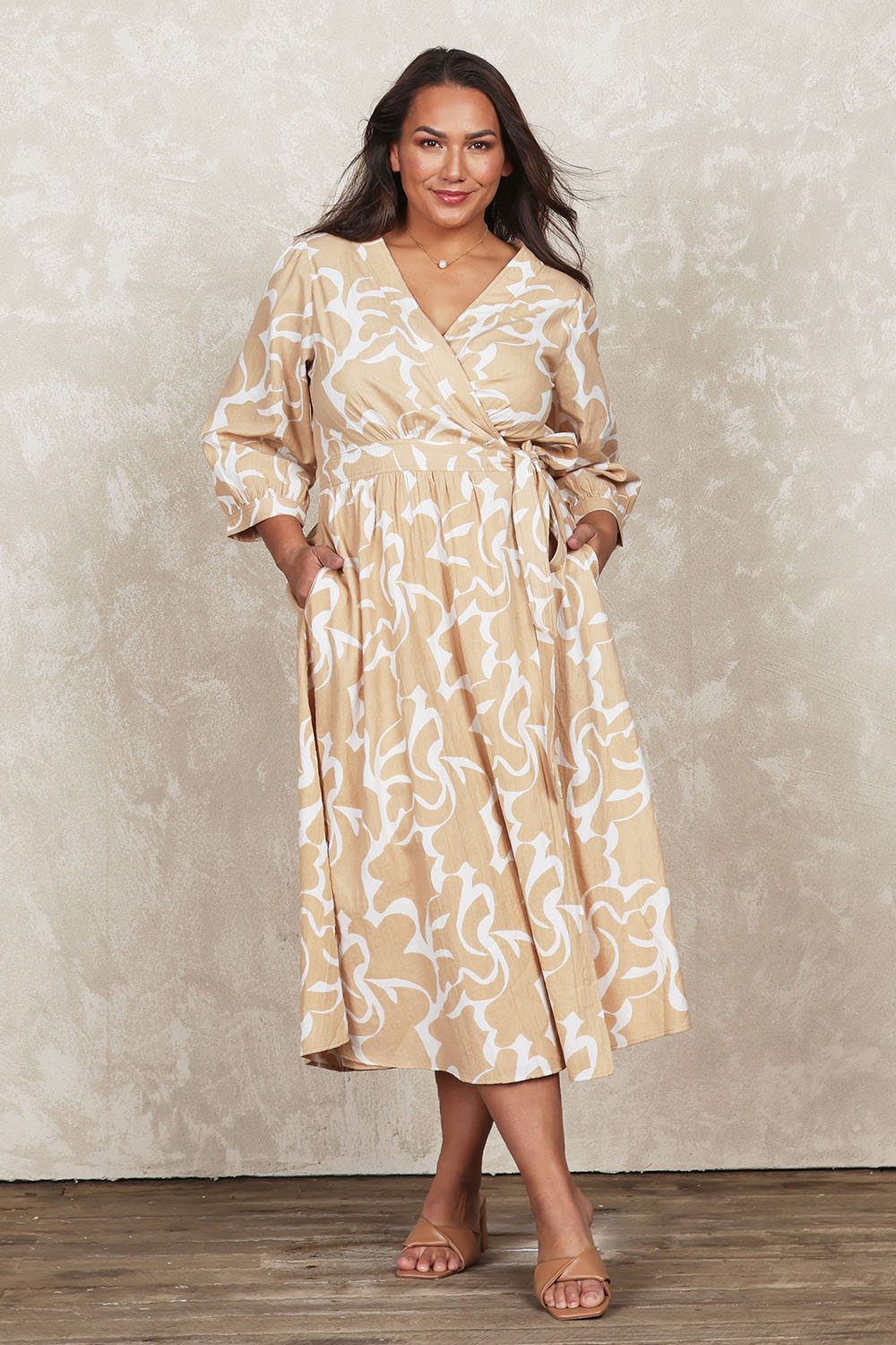 Model Ashleigh wearing size 16 of the Belle Puff Sleeve Wrap Dress in colour Croissant, from the front, showing the whole outfit