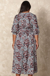 Model Ashleigh wearing size 16 of the Belle Puff Sleeve Wrap Dress in colour Inkwine (Blue), from the back