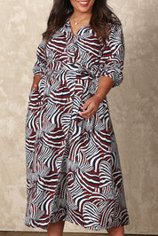 Model Ashleigh wearing size 16 of the Belle Puff Sleeve Wrap Dress in colour Inkwine (Blue), from the front, cropped image
