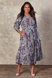 Model Ashleigh wearing size 16 of the Belle Puff Sleeve Wrap Dress in colour Inkwine (Blue), from the front, showing the whole outfit