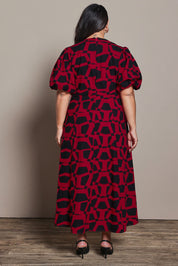 Model Ashleigh wearing size 16 of the Belle Printed Twist Knot Detail Cotton Dress in colour Blackrasp (Black), from the back