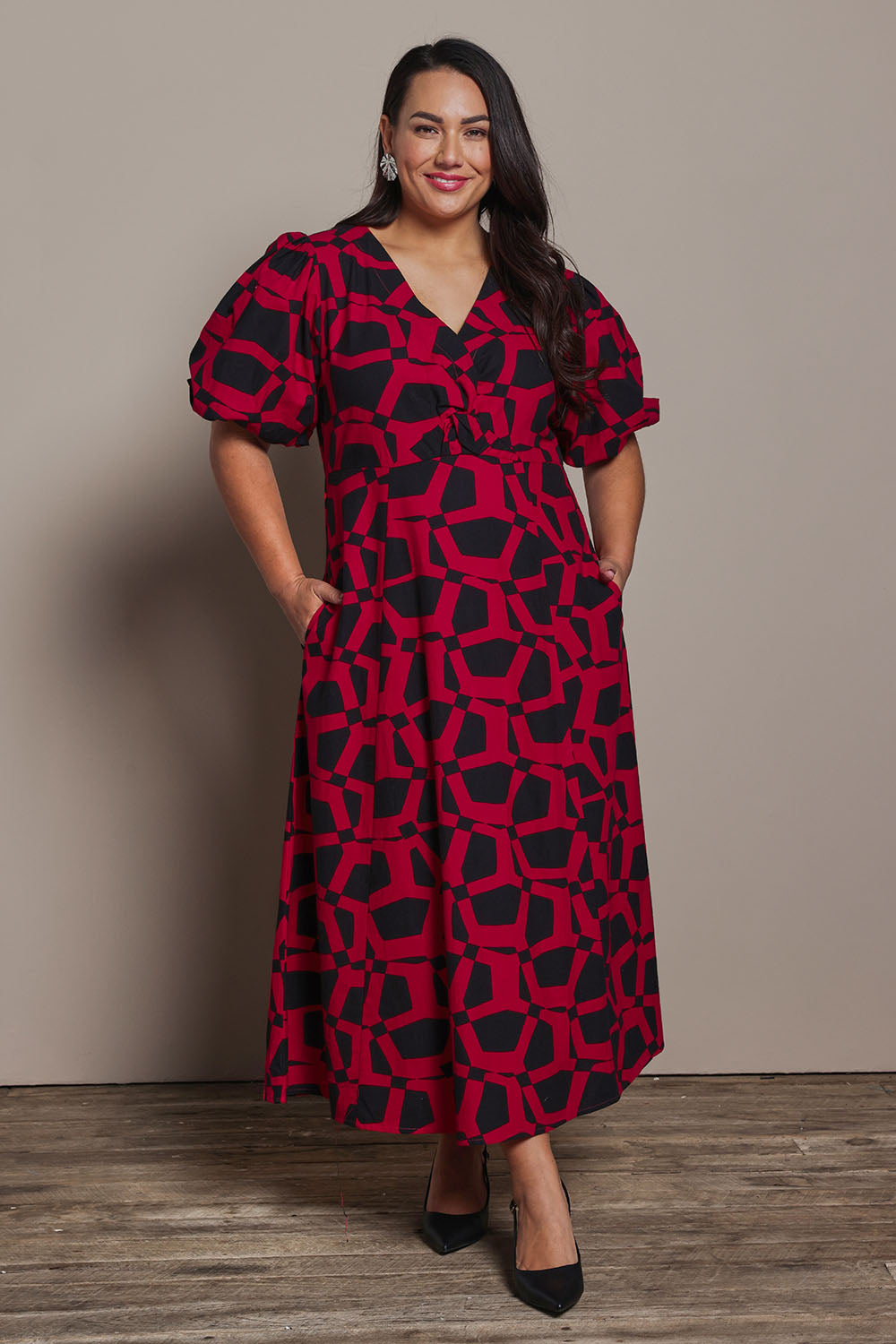 Model Ashleigh wearing size 16 of the Belle Printed Twist Knot Detail Cotton Dress in colour Blackrasp (Black), from the front, showing the whole outfit