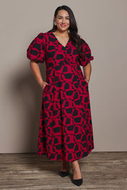 Model Ashleigh wearing size 16 of the Belle Printed Twist Knot Detail Cotton Dress in colour Blackrasp (Black), from the front, showing the whole outfit