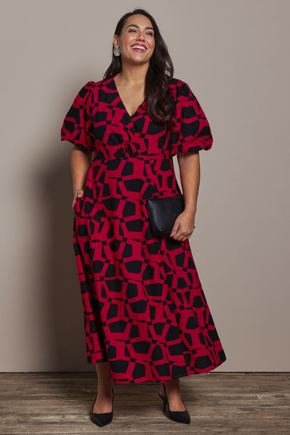 Model Ashleigh wearing size 16 of the Belle Printed Twist Knot Detail Cotton Dress in colour Blackrasp (Black), from the front, showing the whole outfit