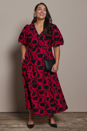 Model Ashleigh wearing size 16 of the Belle Printed Twist Knot Detail Cotton Dress in colour Blackrasp (Black), from the front, showing the whole outfit
