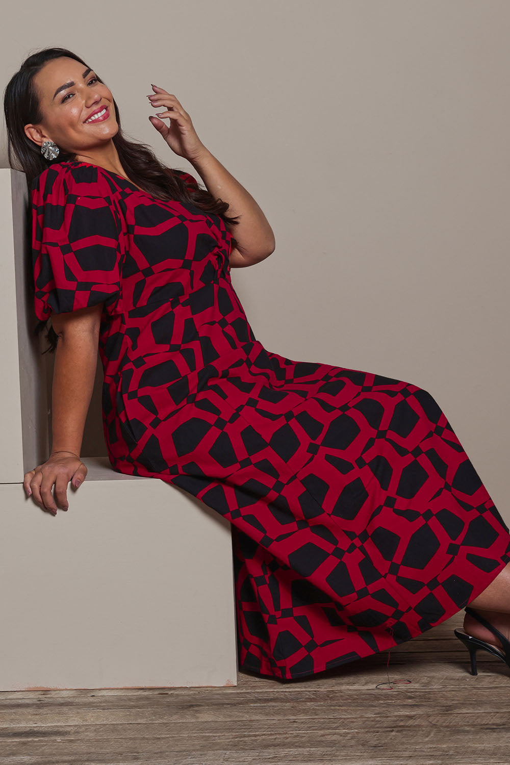 Model Ashleigh wearing size 16 of the Belle Printed Twist Knot Detail Cotton Dress in colour Blackrasp (Black), from the front, showing the whole outfit