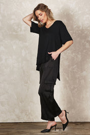 Model Olivia wearing size 10 of the Belle Pull On Satin Cargo Pants in colour Black (Black), from the front, showing the whole outfit