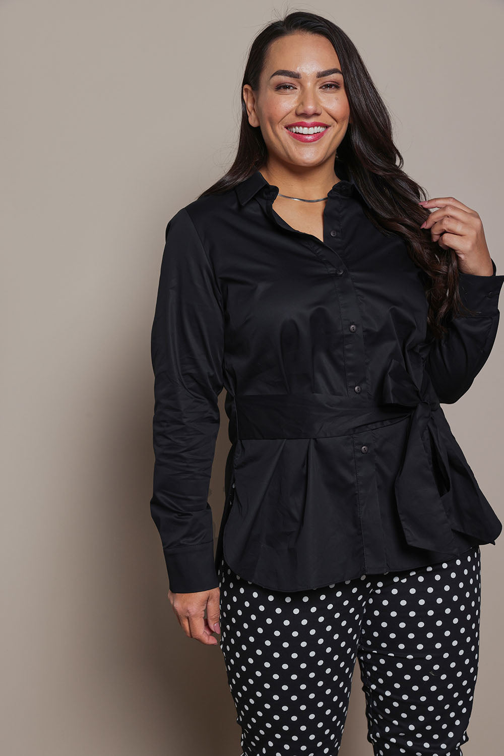 Model Ashleigh wearing size 16 of the Belle Tie Waist Cotton Shirt in colour Black (Black), from the front, cropped image