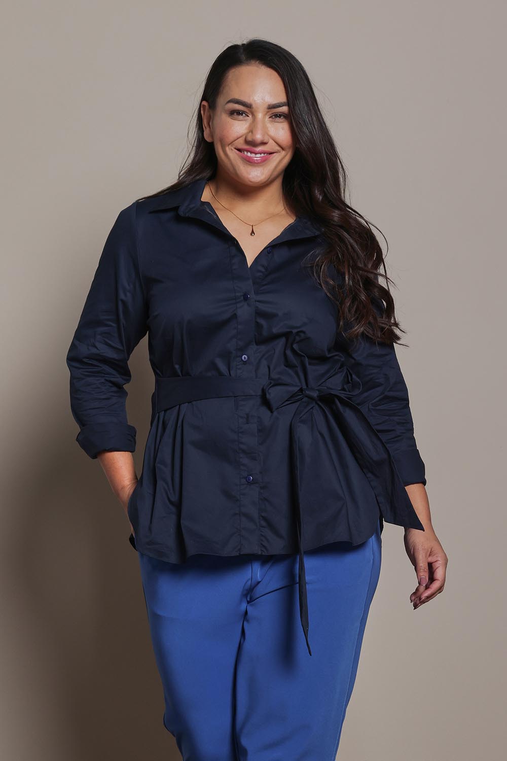Model Ashleigh wearing size 16 of the Belle Tie Waist Cotton Shirt in colour Navy (Blue), from the front, cropped image