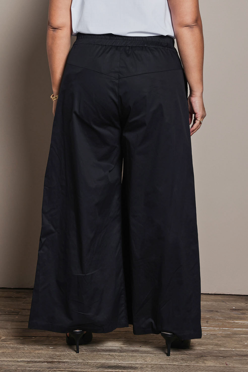 Model Ashleigh wearing size 16 of the Belle Cotton Palazzo Pant in colour Black (Black), from the back