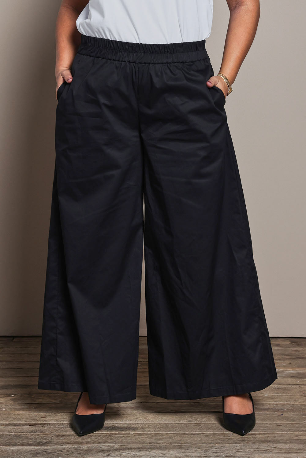 Model Ashleigh wearing size 16 of the Belle Cotton Palazzo Pant in colour Black (Black), from the front, cropped image
