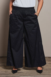 Model Ashleigh wearing size 16 of the Belle Cotton Palazzo Pant in colour Black (Black), from the front, cropped image