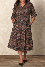 Model Ashleigh wearing size 16 of the Belle Printed Cotton Shirred Dress With Pockets in colour Blackcamel (Black), from the front, cropped image