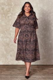 Model Ashleigh wearing size 16 of the Belle Printed Cotton Shirred Dress With Pockets in colour Blackcamel (Black), from the front, showing the whole outfit