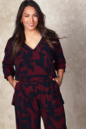 Model Ashleigh wearing size 16 of the Belle Easywear V Neck Pop Over Top in colour Winenavy (Blue), from the front, cropped image