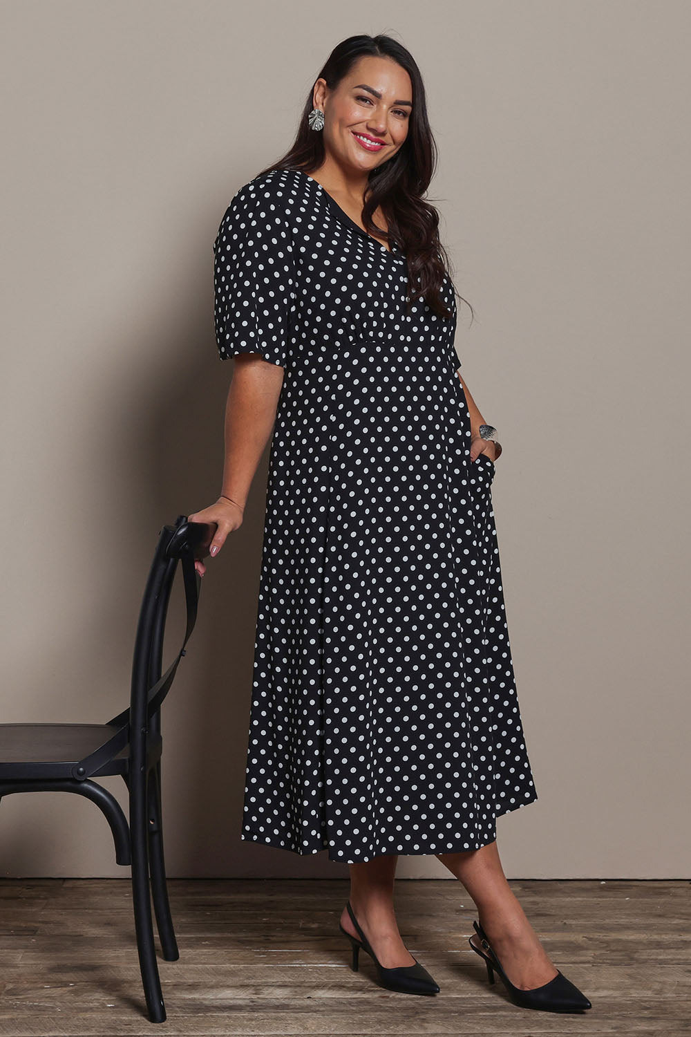Model Ashleigh wearing size 16 of the Belle Fluted A Line Dress With Pockets in colour Blackwhite (Black), from the front, showing the whole outfit