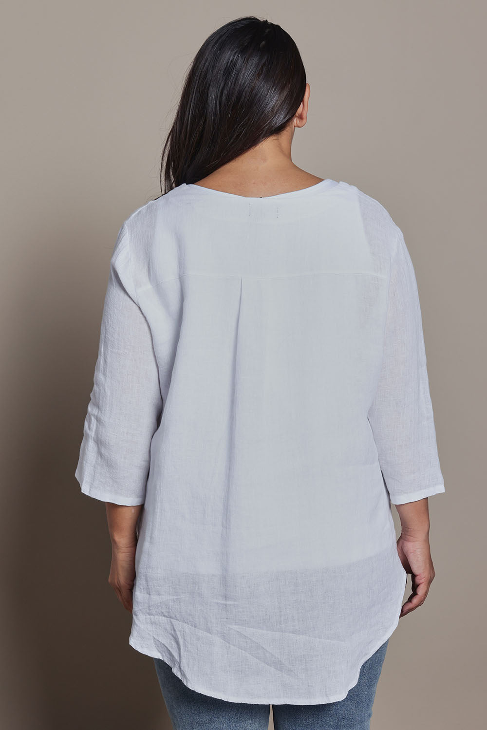 Model Ashleigh wearing size 16 of the Belle High Low Linen Top in colour White (White), from the back
