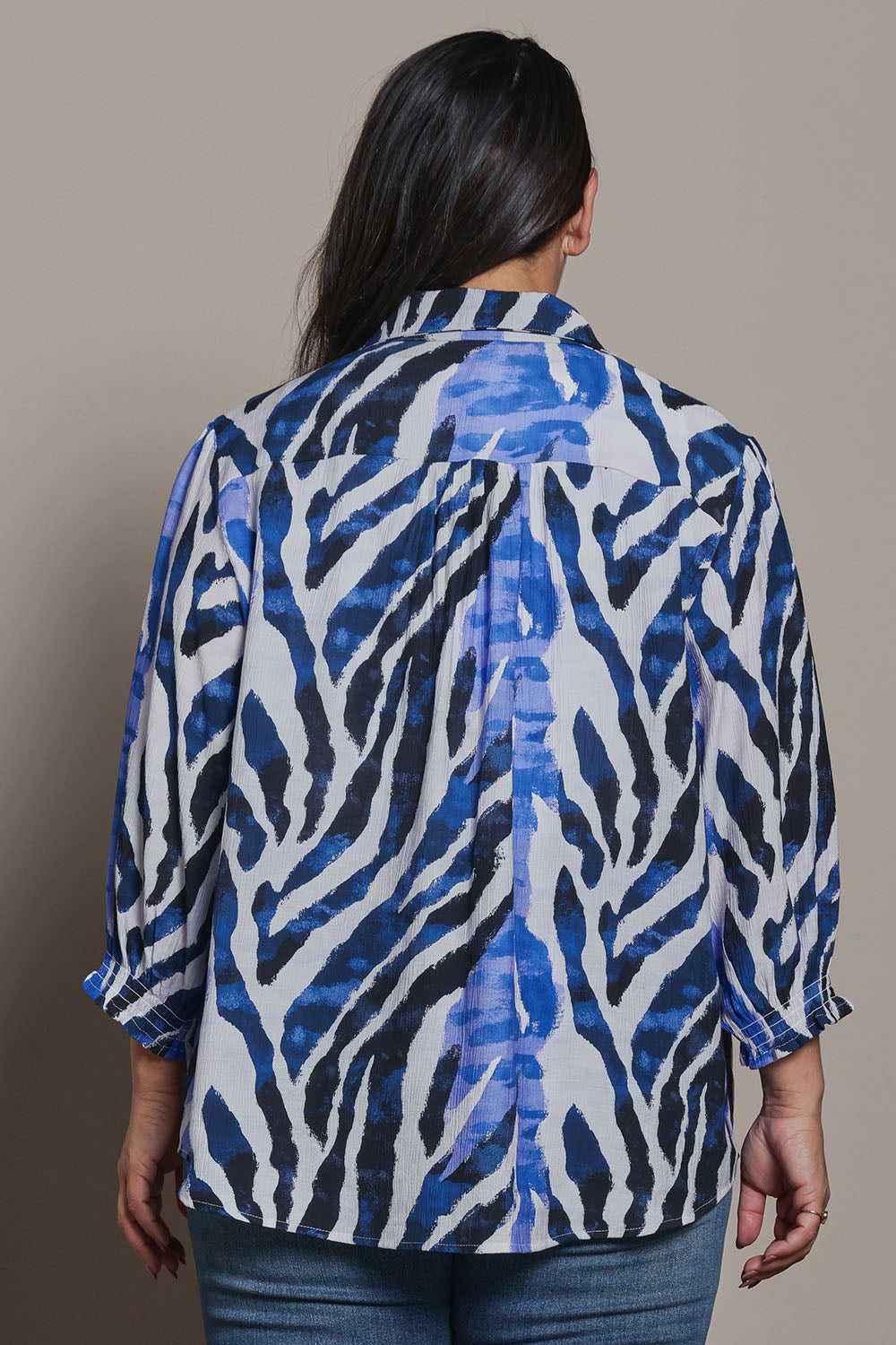Model Ashleigh wearing size 16 of the Belle Printed Shirred Sleeve Shirt in colour Bluezebra (Blue), from the back