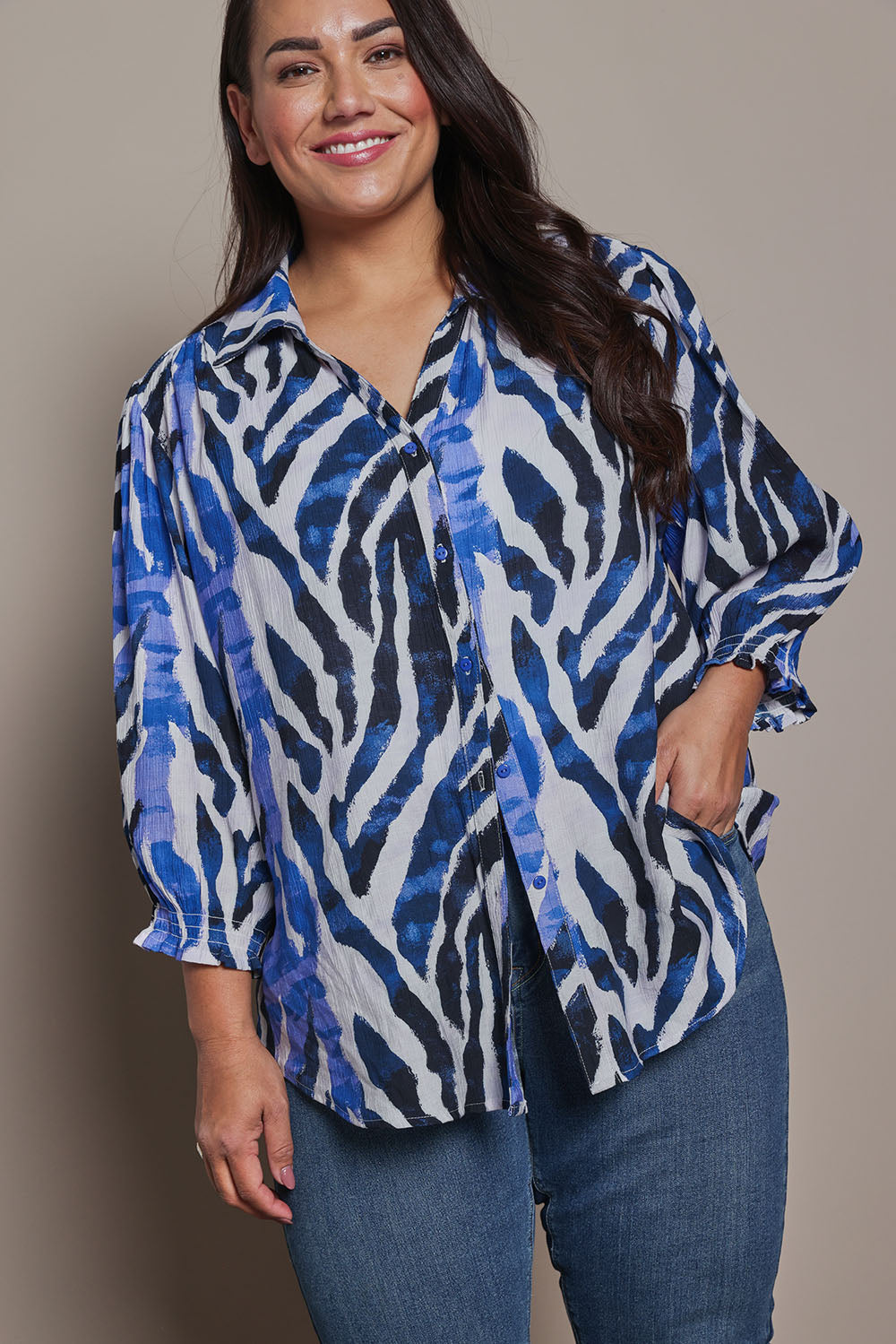 Model Ashleigh wearing size 16 of the Belle Printed Shirred Sleeve Shirt in colour Bluezebra (Blue), from the front, cropped image
