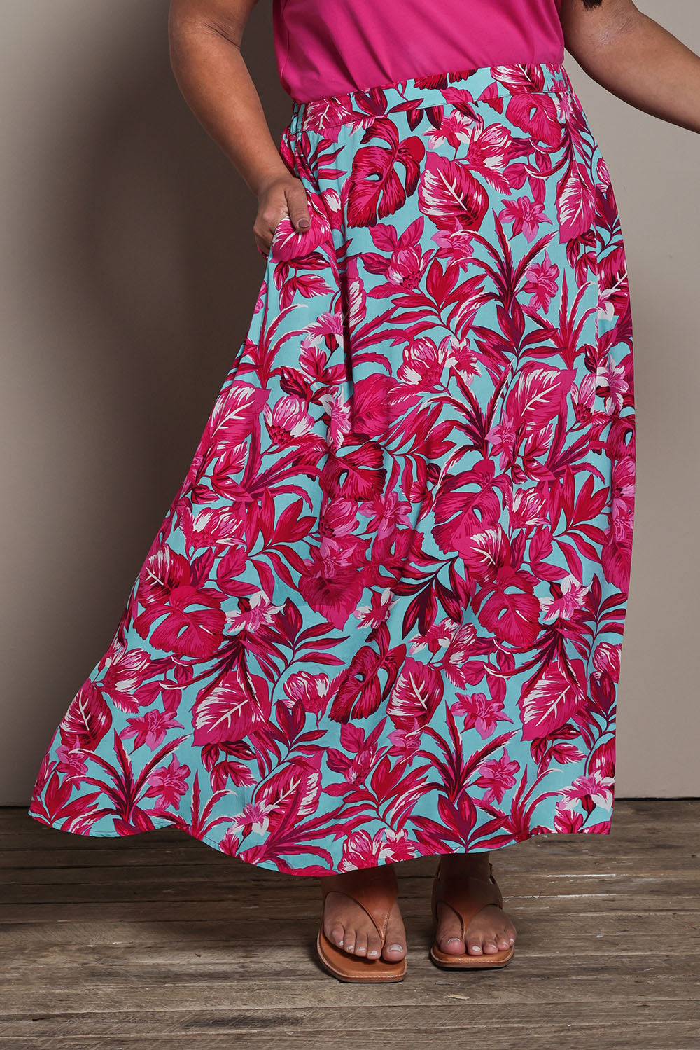 Model Ashleigh wearing size 16 of the Belle Printed Pull On Full Skirt with Pockets in colour Aquafusch (Pink), from the front, cropped image